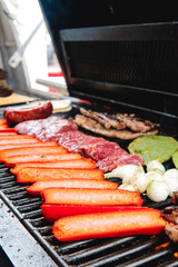 A grill with sausages accommodated, beef, nopales and onions. Meat about to roast. Hearty food on the grill. red meats Butcher shop with meat grill. Commit meat. Steakroaster.