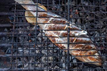 Appetizing sibas fish grilling on barbecue. Summer rest concept