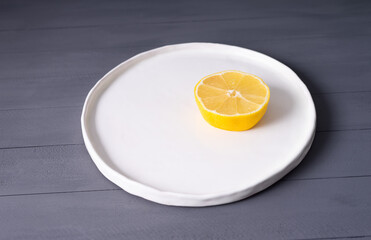 lemon on flat  white plate handmade on a gray wooden table. looks like fried eggs