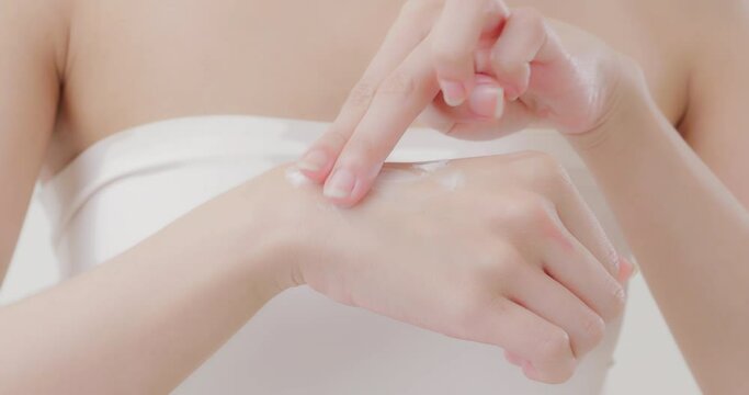 Slow-motion beauty Asian young woman hand cream. Beautiful female model with perfect clean fresh skin. Skin care treatment concept