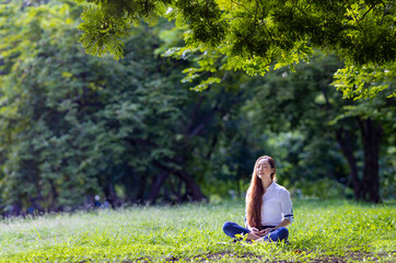Woman relaxingly practicing meditation in the forest to attain happiness from inner peace wisdom for healthy mind and soul