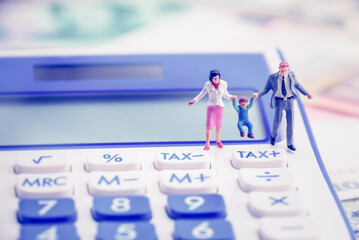 Family tax benefit or FTB / child care fee concept : Couple holds a child on a calculator, depicts...