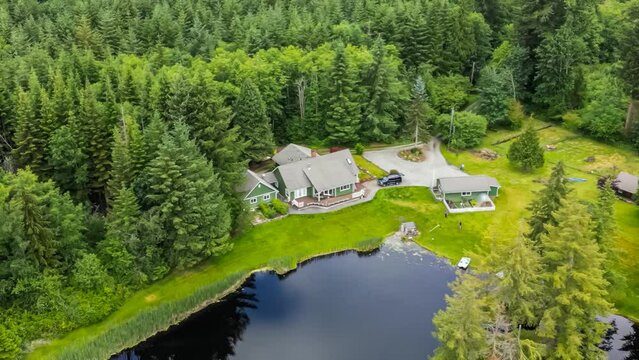 Aerial view of a modern American suburban home near a small lake in a rural fore