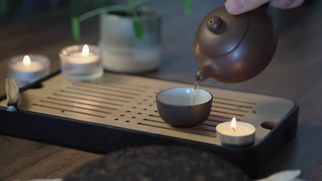 Chinese tea ceremony with puerh tea, Brewing black Shu Pu-erh Tea in pot from clay, boiling water pours into kettle, close up
