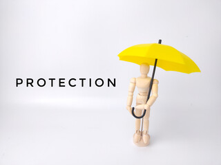 Wooden mannequin holding yellow umbrella with the word PROTECTION on a white background. Insurance...