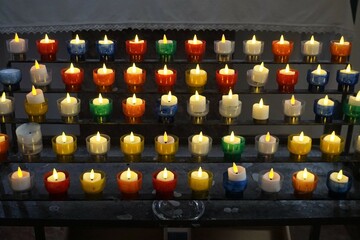 Reihen bunter Kerzenlichter in Kirche 