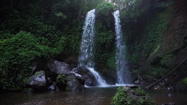 beautiful static shot of the grenjengan kembar waterfalls in the middle of the jungle in central java indonesia