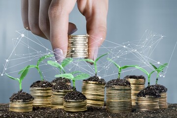 Hand stacked coins with money saving concept and profit graph business finance on a background.
