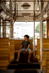 Fototapeta na wymiar a boy rides a trama boy rides a tram, a child views the city through the window of public transport.