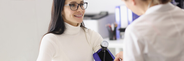 Doctor measuring patients blood pressure with tonometer tool and talk