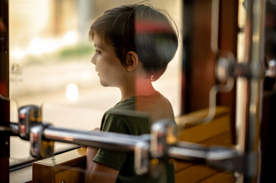 A Boy Rides A Trama Boy Rides A Tram, A Child Views The City Through The Window Of Public Transport.