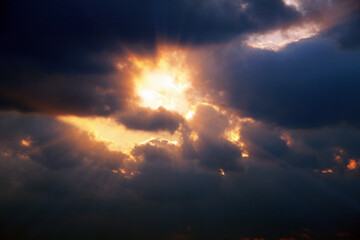 흐린 하늘 먹구름 사이로 비치는 태양 빛줄기와 붉은 광선

