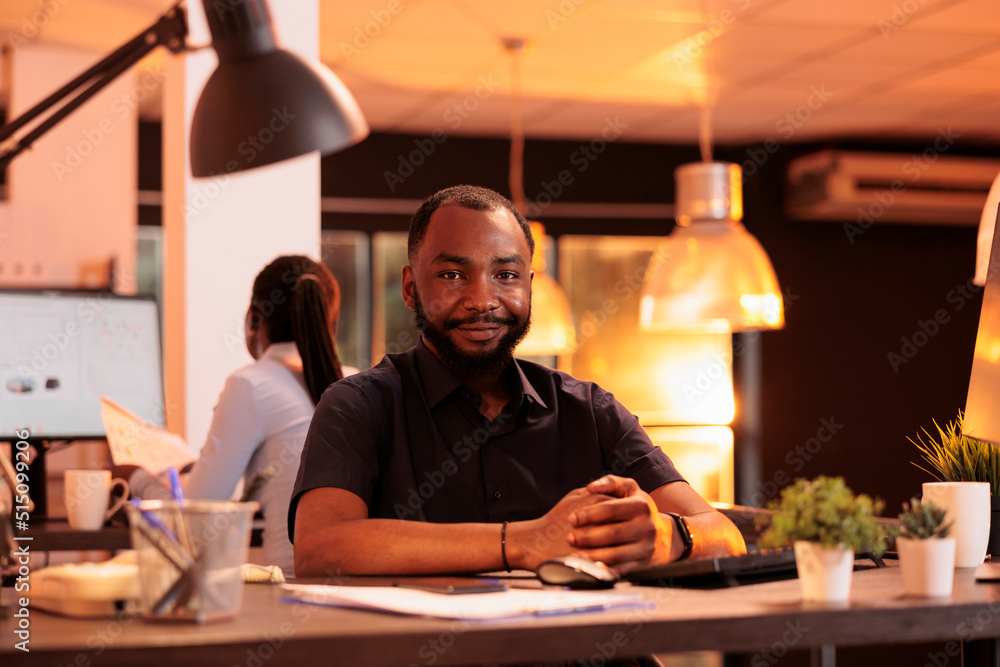 Poster portrait of african american man working on computer at desk during sunset, using data network. crea