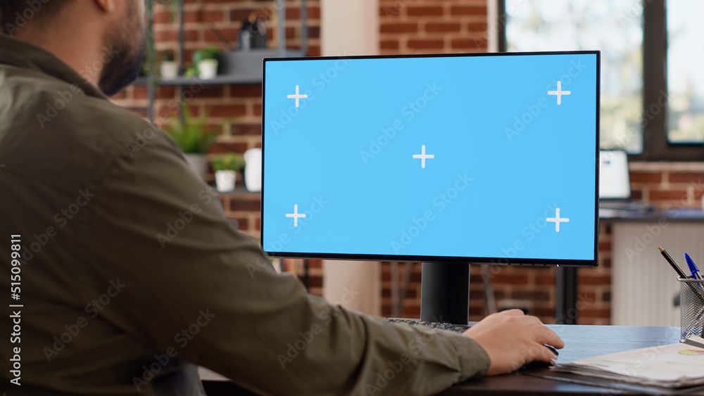 Poster company manager looking at computer with greenscreen to work on startup business, using blank chroma