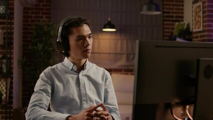 Company worker listening to podcast episode or webinar, using computer to do remote work for startup business. Training class lecture to learn job report on online application. Handheld shot.