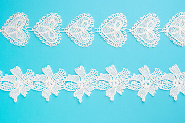 White lace with flowers and heart with pattern on blue horizontally