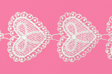 White laces with hearts on pink background isolated horizontally