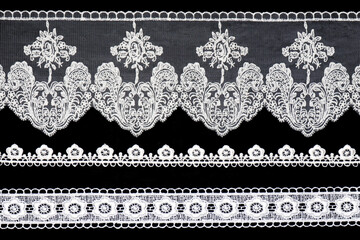 Set white laces with flowers isolated on black background horizontally