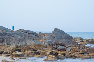 Fototapeta na wymiar rocks and man on seashore