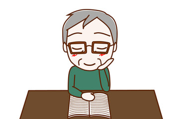 （上半身正面）机に座って本を楽しく読んでいる高齢の男性