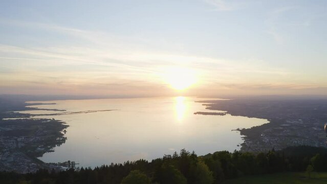 Aerial view passing telecommunications tower on Alpine woodland hillside overlooking Lake Constance, Austria