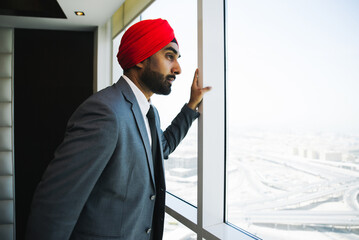 Indian businessman looking out the window in his office