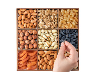 Hand with assorted nuts and dried fruit collection. Different superfoods. Vegetarian snack of...