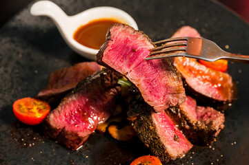 sliced beef steak on black plate,Food concept background.