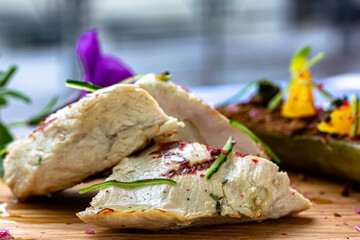 Grilled chicken or turkey breast with fresh vegetable salad on a white plate over dark green slate, stone or concrete vegetable.