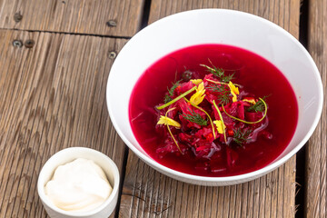 Vegetable cold soup with beet, cucumber, radsih and egg on wooden table