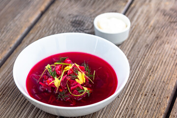 Vegetable cold soup with beet, cucumber, radsih and egg on wooden table