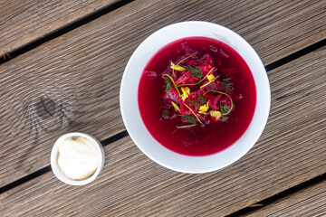 Vegetable cold soup with beet, cucumber, radsih and egg on wooden table
