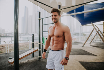 Handsome young man making functional training outdoor in the city. Fit muscular athlete making sport and fitness in an urban area