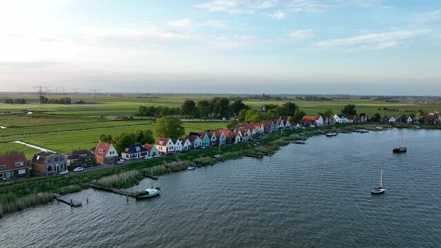 Durgerdam local dyke village with old traditional wooden houses in the north of Amsterdam. Harbour maritime countryside aerial landscape at sunset. Dutch Holland landscape.