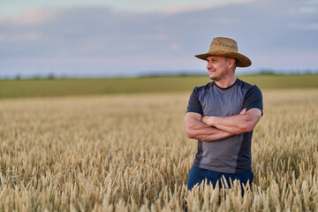 Naklejka na ściany i meble Happy farmer in a wheat field