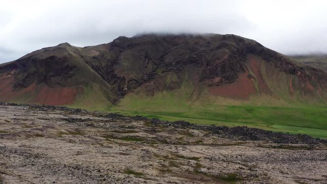 Aerial of Mountain Covered with Grass at the Bottom and with Mudflows in Front