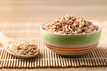 Thai brown rice seed in bowl with spoon, Organic rice grain, Food ingredients