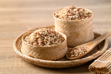 Thai brown rice seed in bamboo basket with spoon, Organic rice grain, Food ingredients