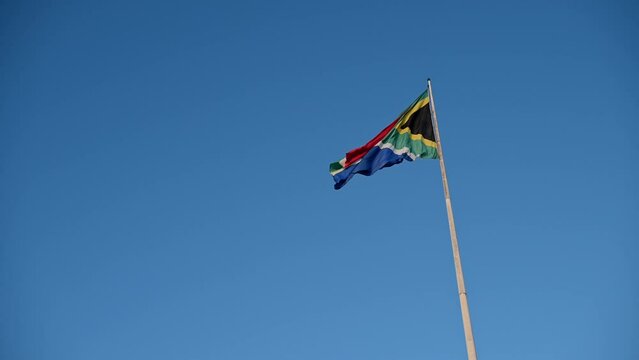 Low angle view of South African flag seen against clear sky