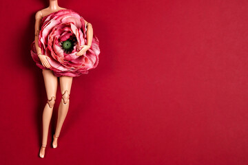 Plastic doll female body with peony flower on belly. Women's health, beauty and care.