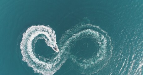 Aerial top view of a white pleasure boat on a summer day. Powerboat turn loop eight on the sea making metaverse infinity future concept.  - obrazy, fototapety, plakaty