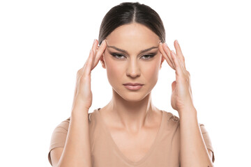 Fototapeta premium Young woman tightening her face skin with her fingers on a white background