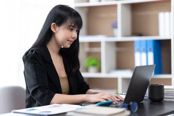 Portrait of Asian young female working on laptop at office