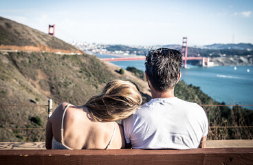 Couple sitting on a bench and watching San francisco landscape