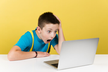 Surprised boy hand on head watching social media content isolated on yellow background. Parental...