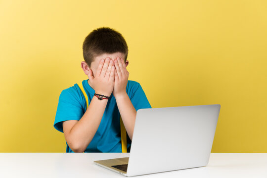 Teenager boy hands on face whatching inappropriate content for his age on laptop isolated on yellow background. - Powered by Adobe