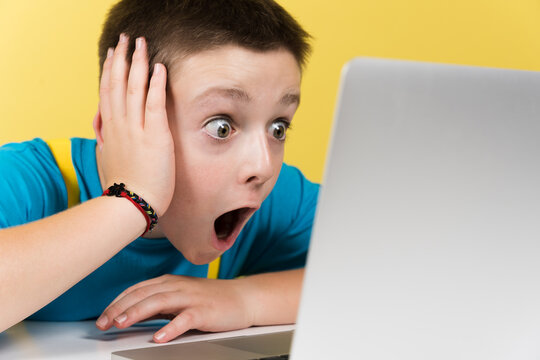 Closeup portrait of surprised boy in front of laptop. - Powered by Adobe