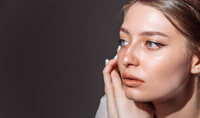 Profile of a beautiful woman with flawless blue eyes, dark hair. copy space.