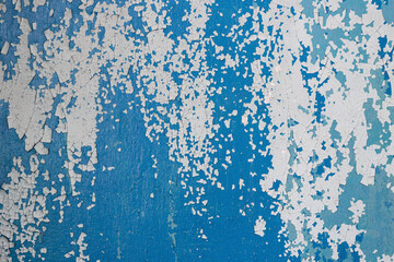 Fototapeta premium Peeling paint on the wall. Old concrete wall with cracked flaking paint. Weathered rough painted surface with patterns of cracks and peeling. Grunge texture for background and design. High resolution.