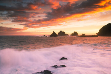 夕焼けの蓑掛岩と大波